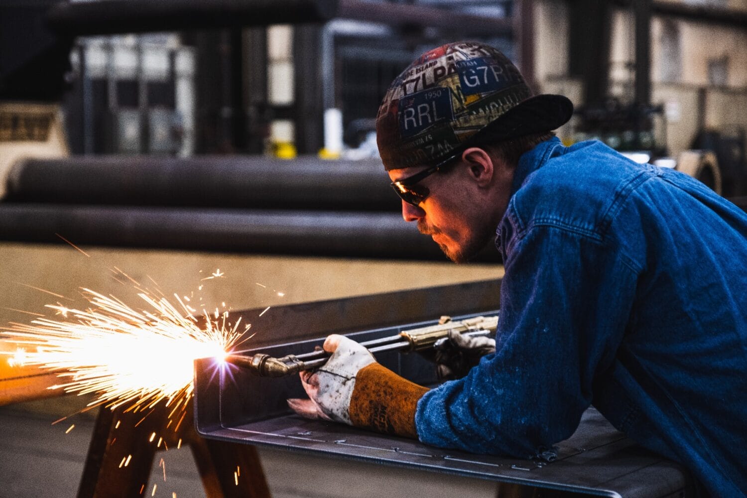 Technician using a cutting torch to fabricate a steel component in the Hi-Vac manufacturing facility